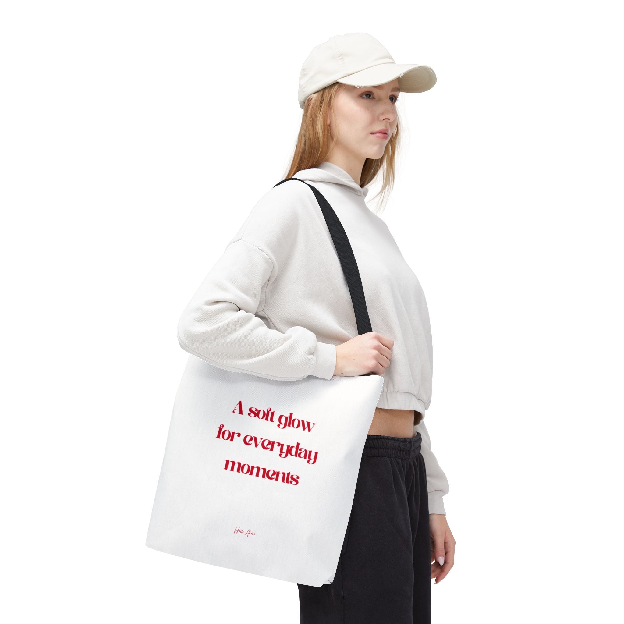 Person holding a white tote bag with red text on a white background