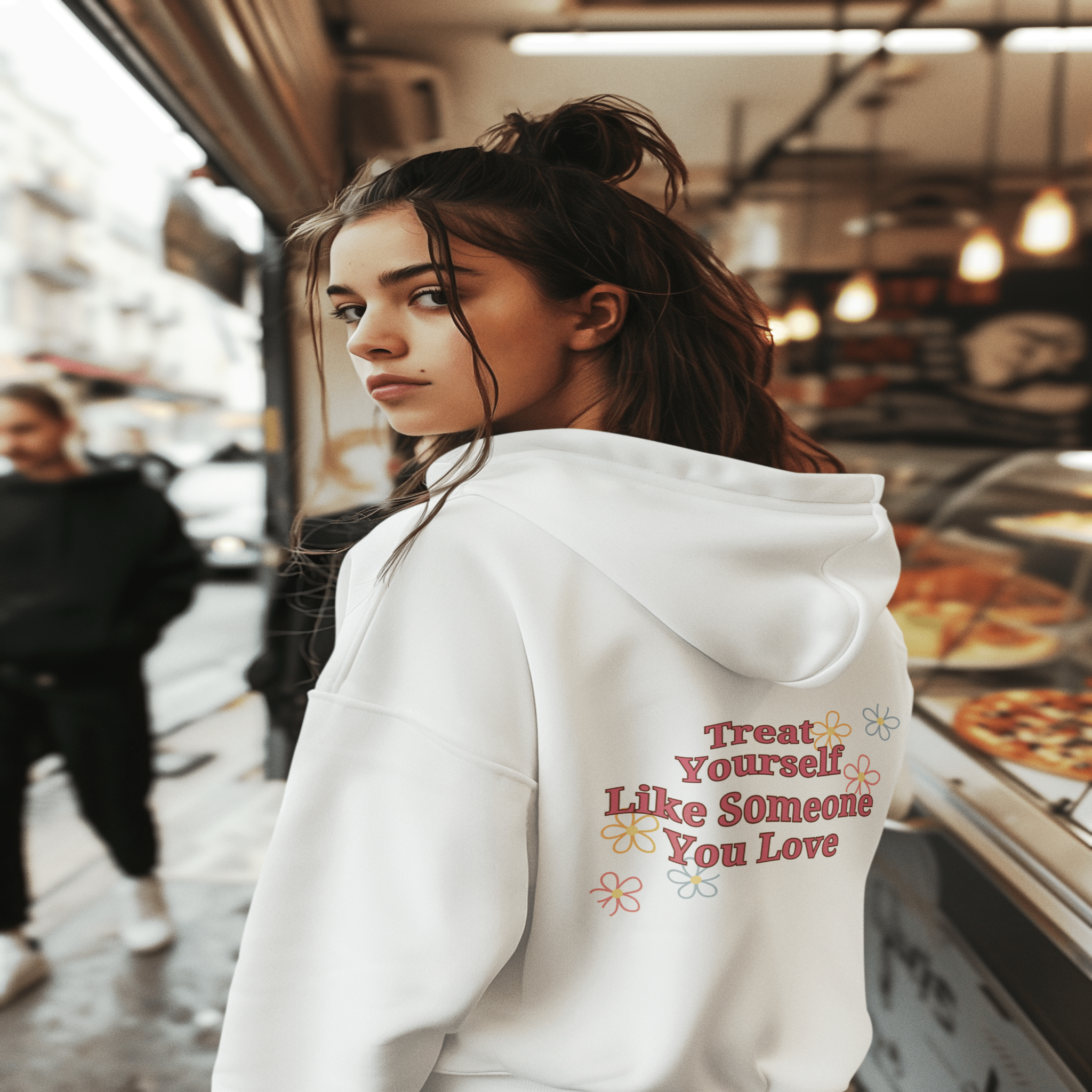 Woman wearing light gray self love hoodie with motivational quote and flower illustrations